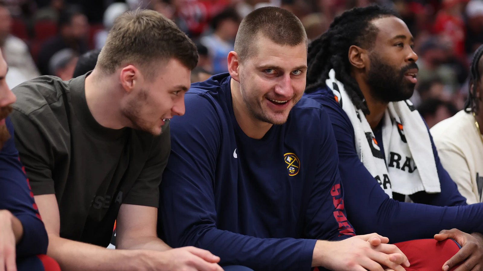 Nikola Jokić grinning on the Denver bench next to a laughing Luka Dončić — Kevin Carangui's 1.1 pick, the most valuable player in the league